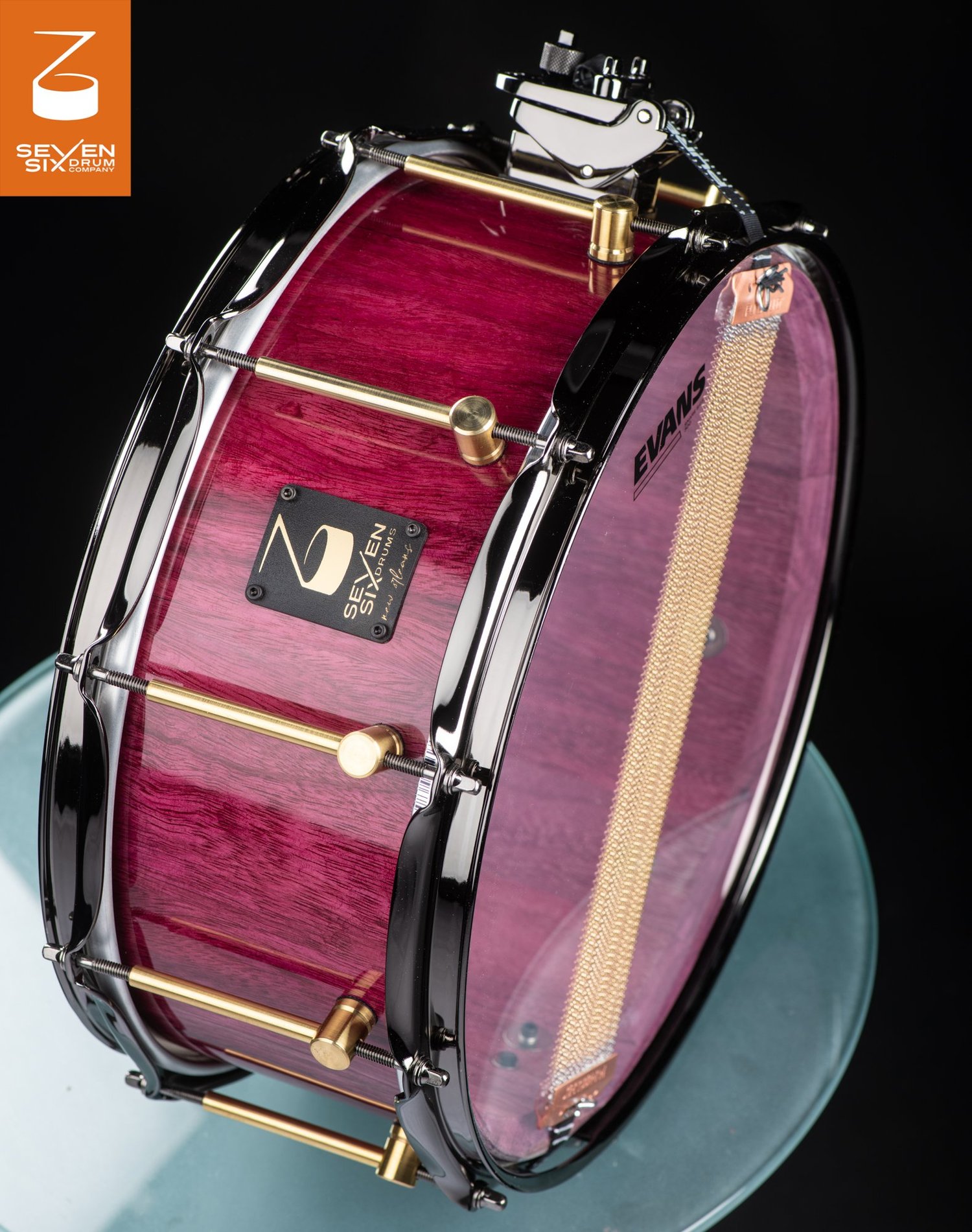 Handmade snare drum with a gloss purple wood shell, brass lugs, and black chrome hoops.