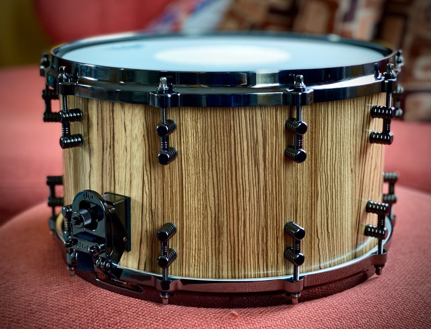Handmade snare drum with a natural zebrawood shell, satin finish, and black nickel hardware.