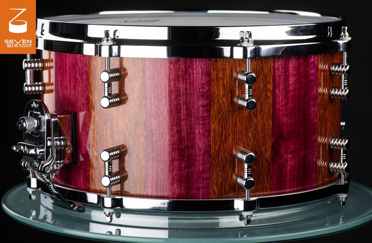 Handmade snare drum with a high-gloss purple and brown striped wood shell, chrome hoops, and chrome lugs.
