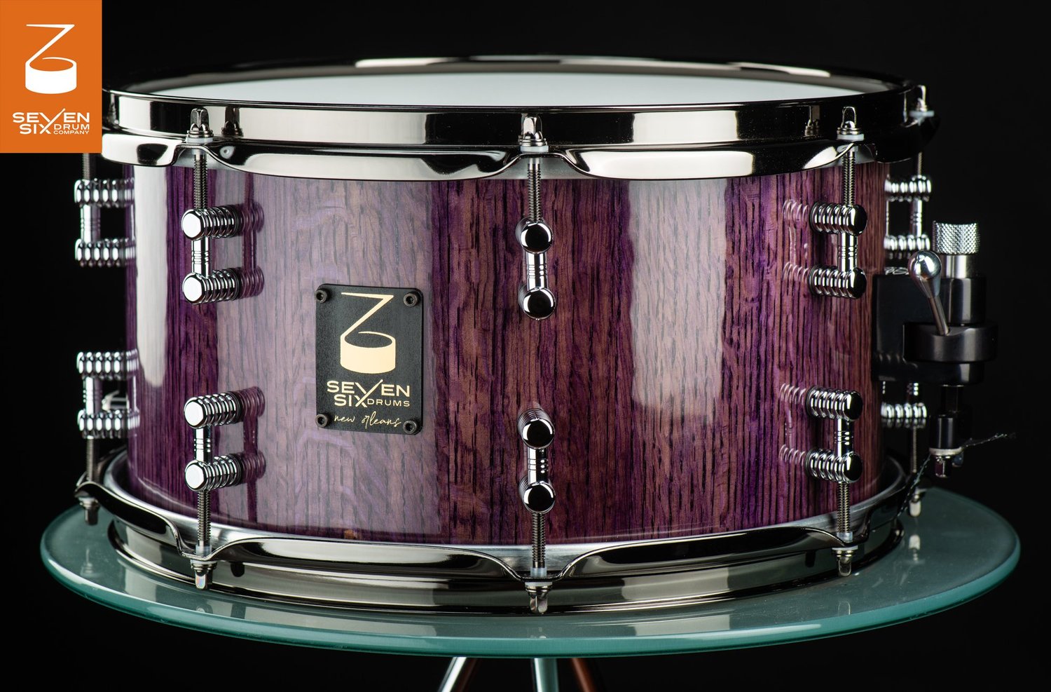 Handmade snare drum with a high-gloss purple wood shell, chrome hoops, and polished chrome lugs.
