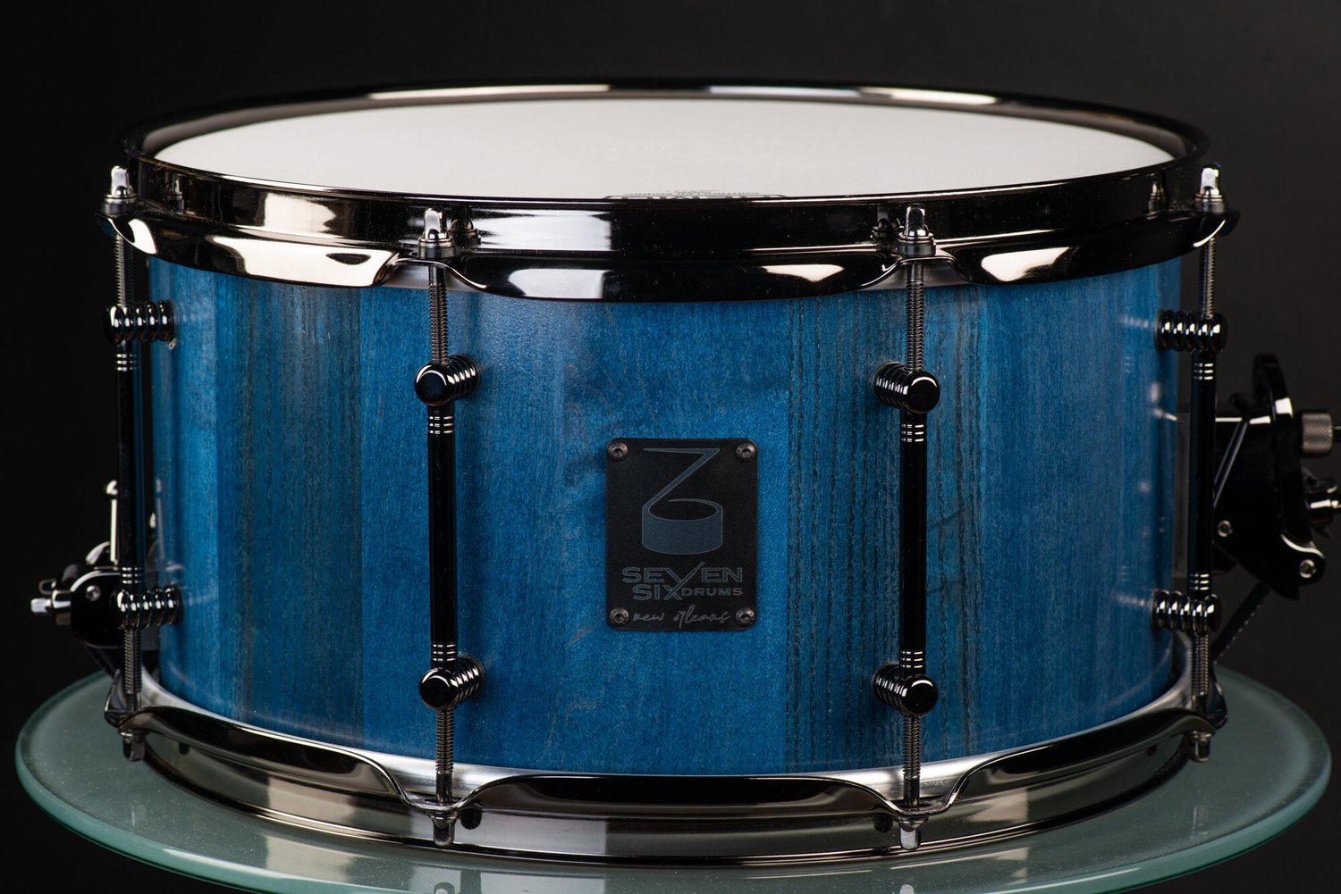 Handmade wood snare drum with a blue stained finish, black nickel hoops, and tube lugs.