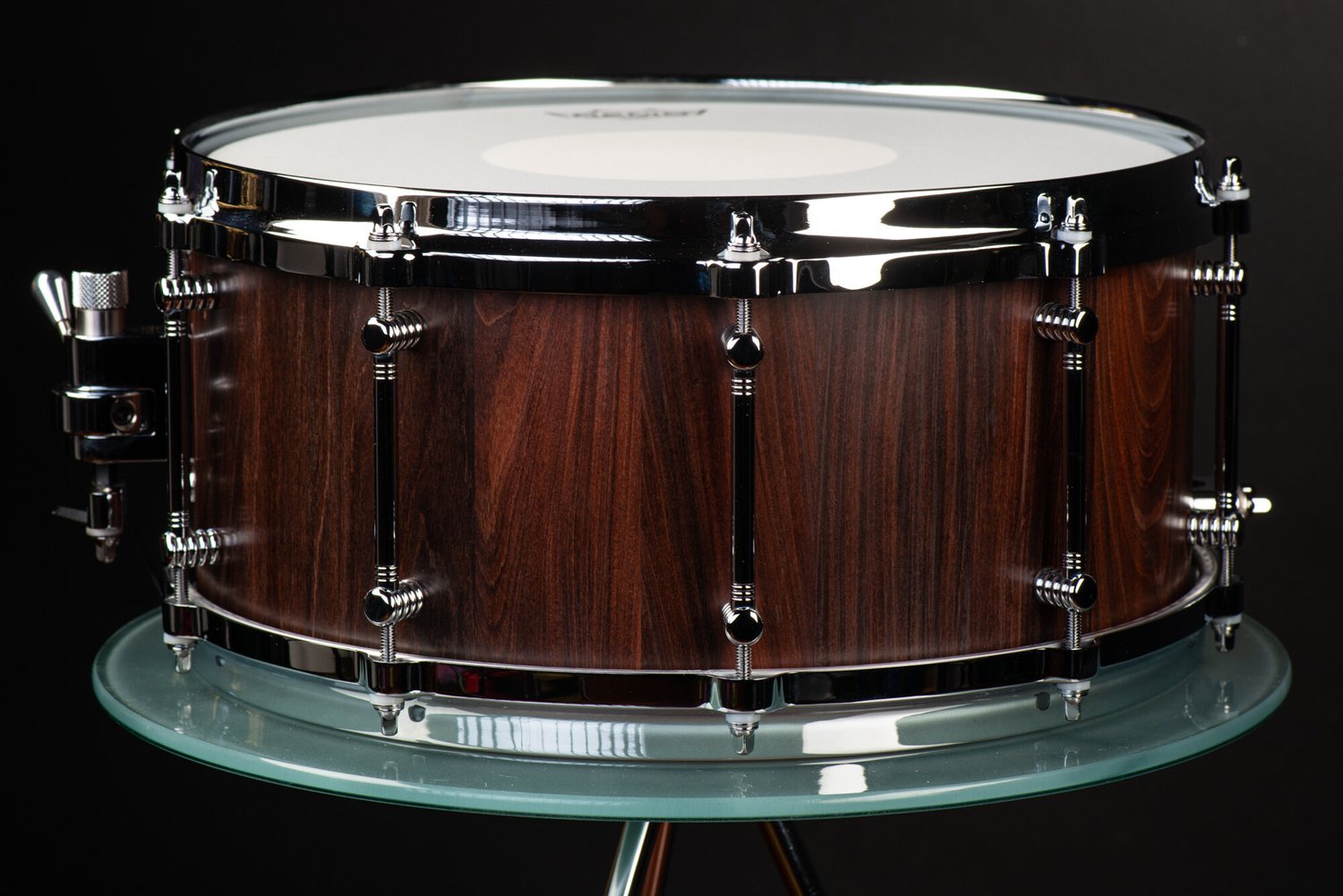 Handmade snare drum featuring a dark walnut shell with a satin finish, chrome tube lugs, and polished hoops.