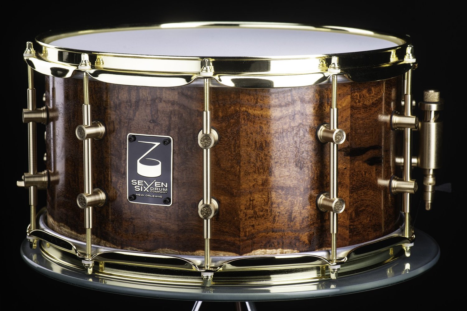 Handmade Granadillo snare drum featuring a satin figured wood shell, polished brass hoops, and brass tube lugs.
