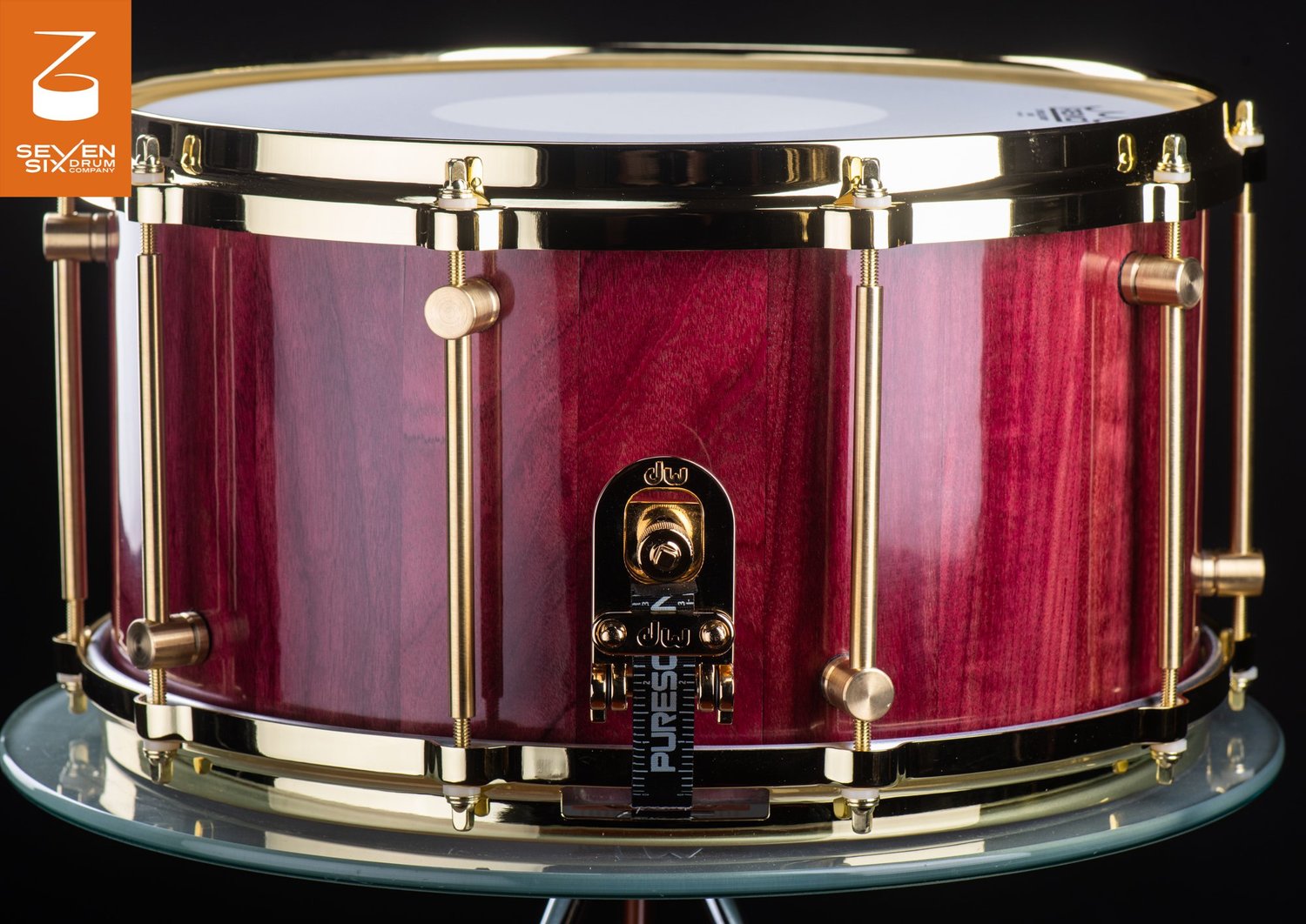 Handmade purpleheart wood snare drum in a gloss finish with polished brass hoops and tube lugs.
