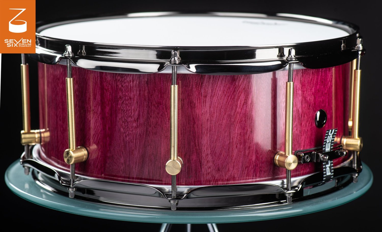 Purpleheart wood snare drum with a gloss finish, brass tube lugs, and black nickel hoops.