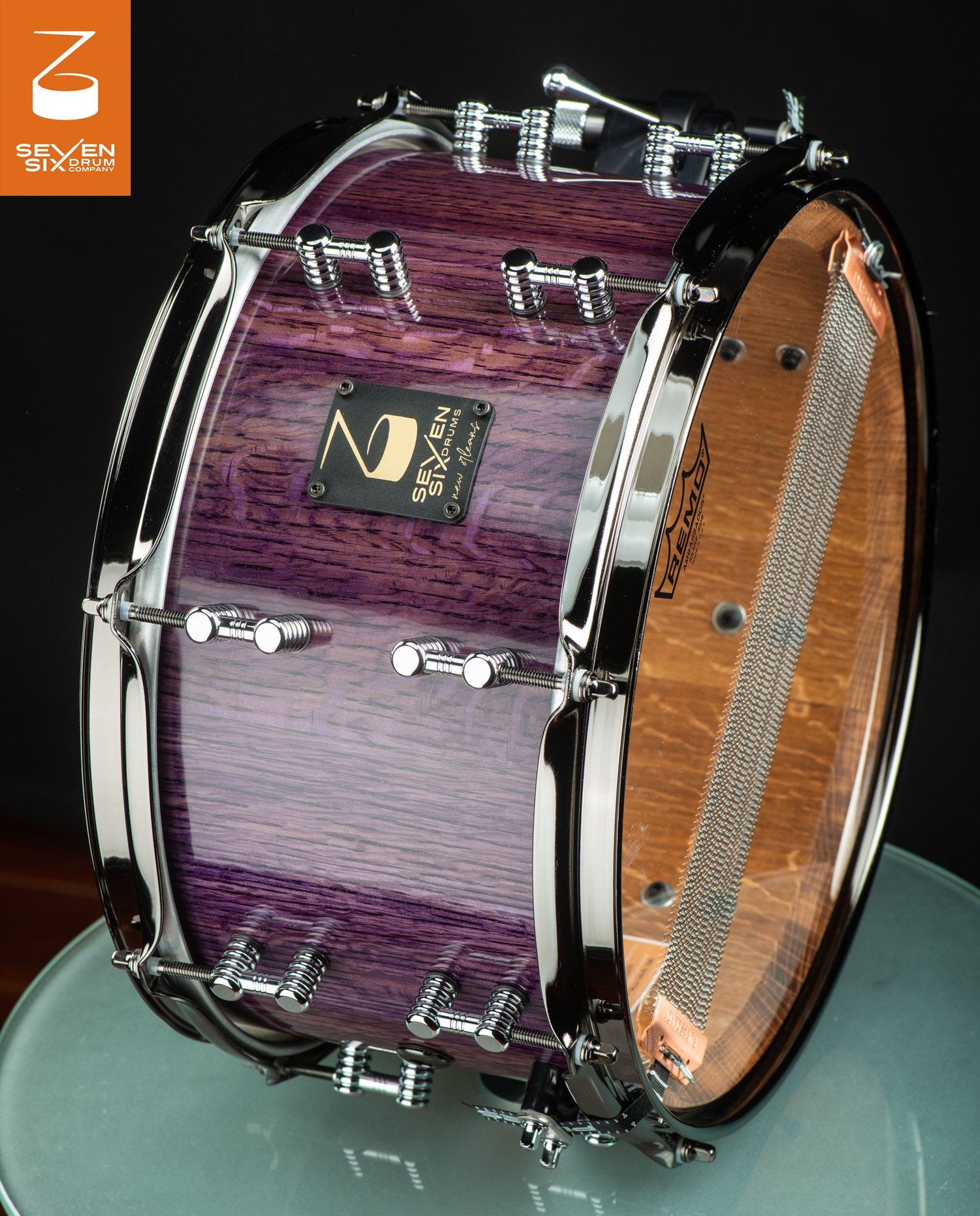 Handmade snare drum with a glossy purple wood shell, chrome lugs and hoops, and bottom snare wires.