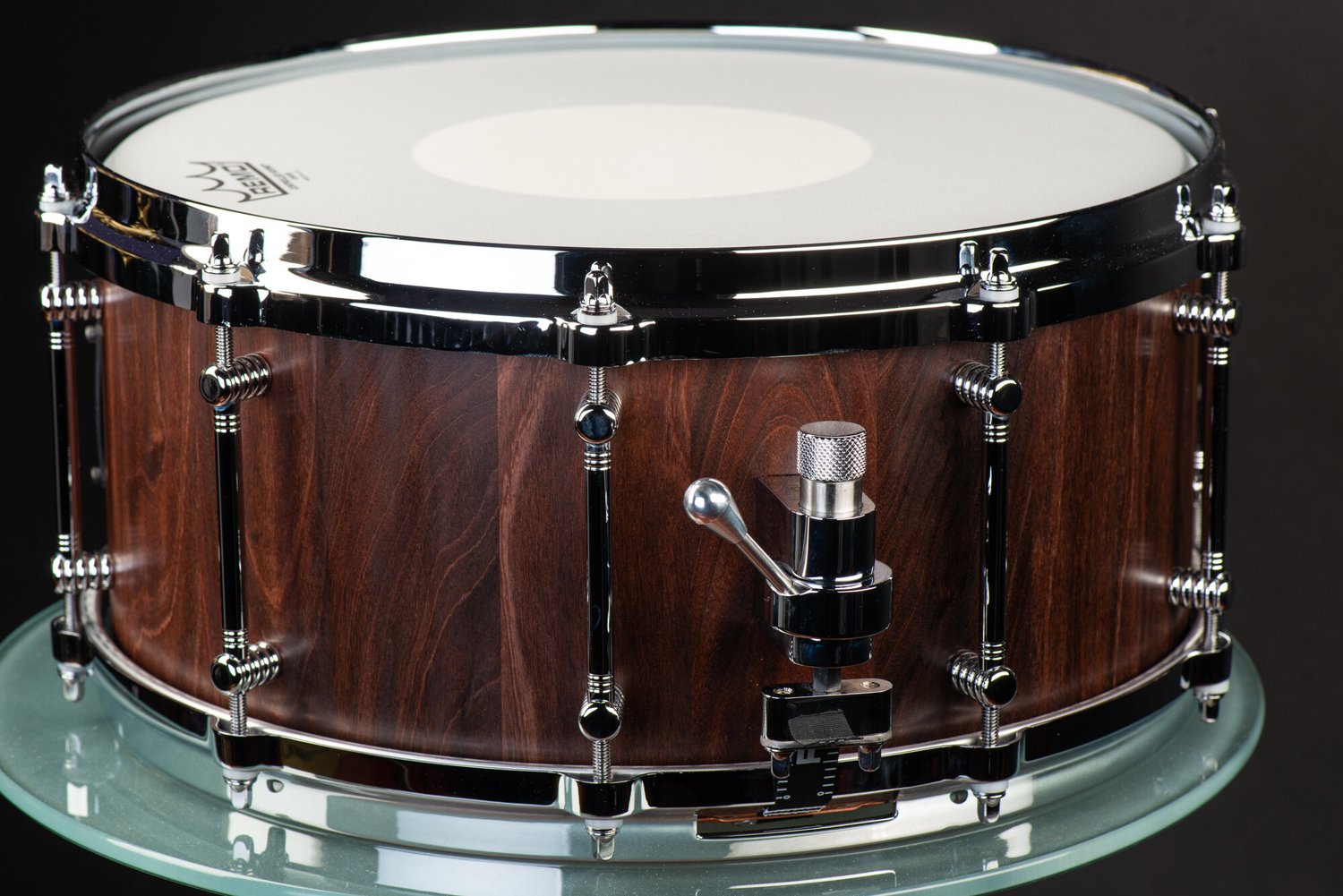 Handmade snare drum with a dark walnut satin finish, polished chrome tube lugs, and an adjustable throw-off.