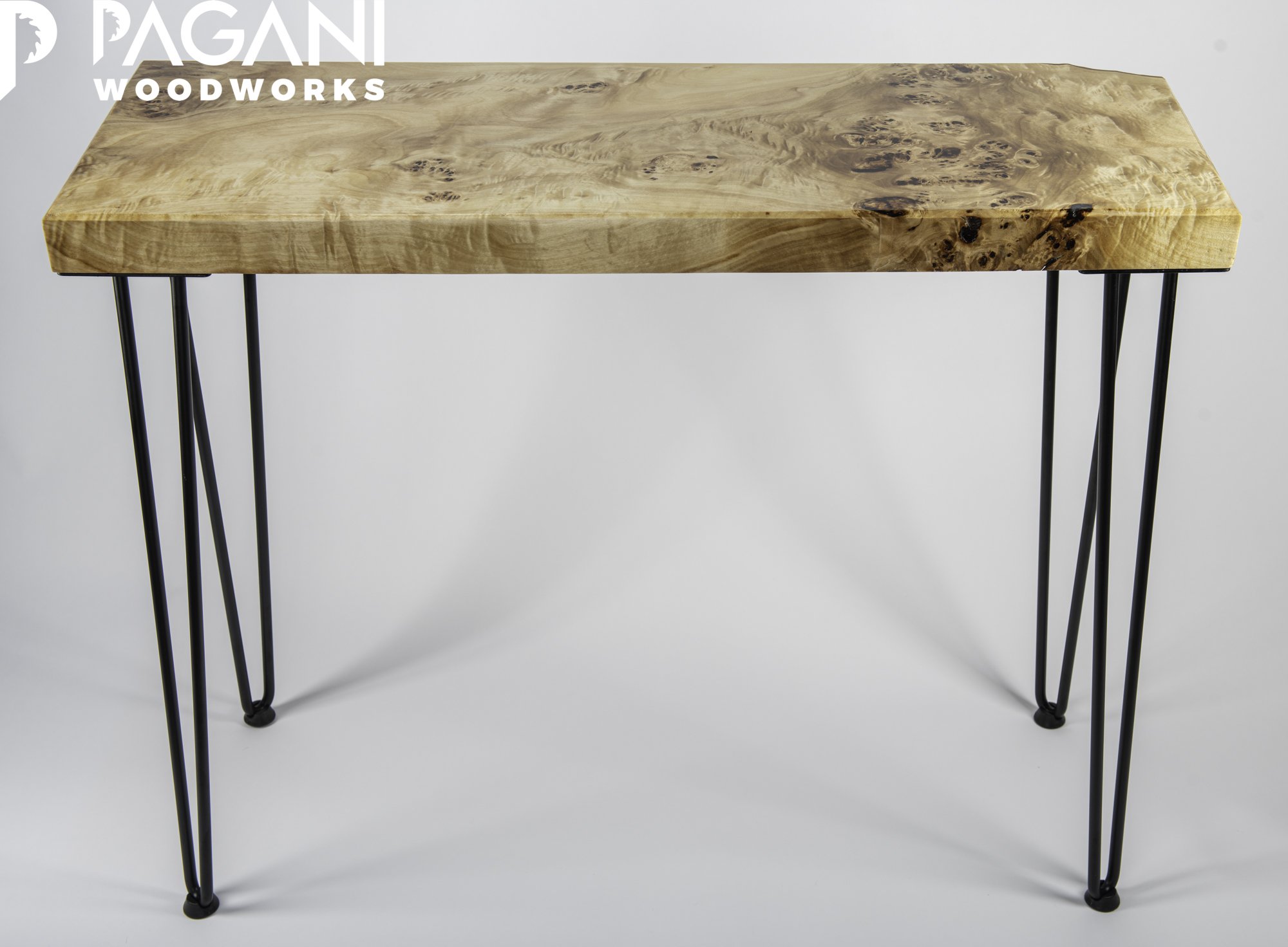 Handmade table with a natural finish burl wood slab top and black metal hairpin legs.