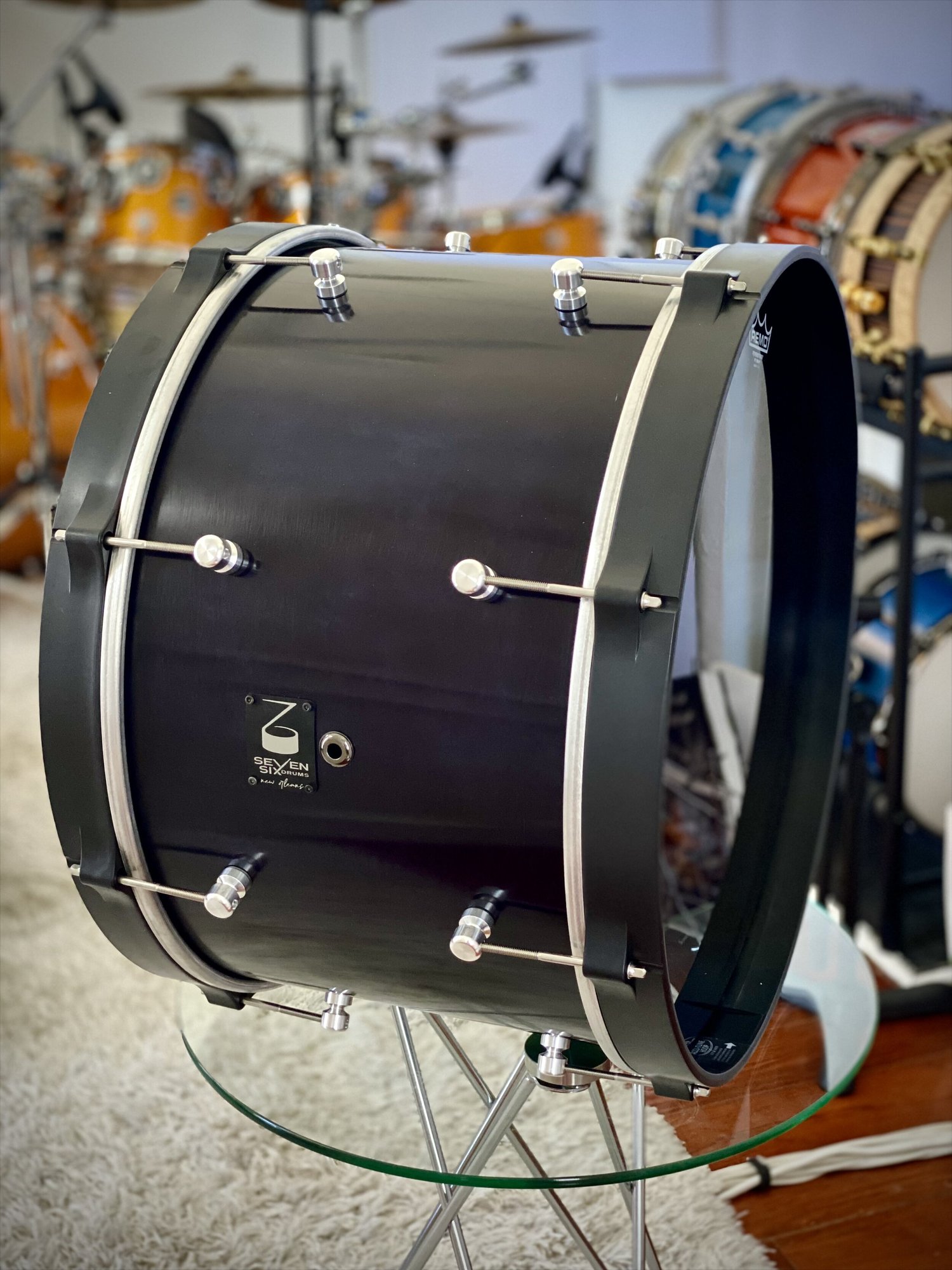 Handmade bass drum featuring a satin black wood shell, matching hoops, and minimalist chrome cylinder lugs.