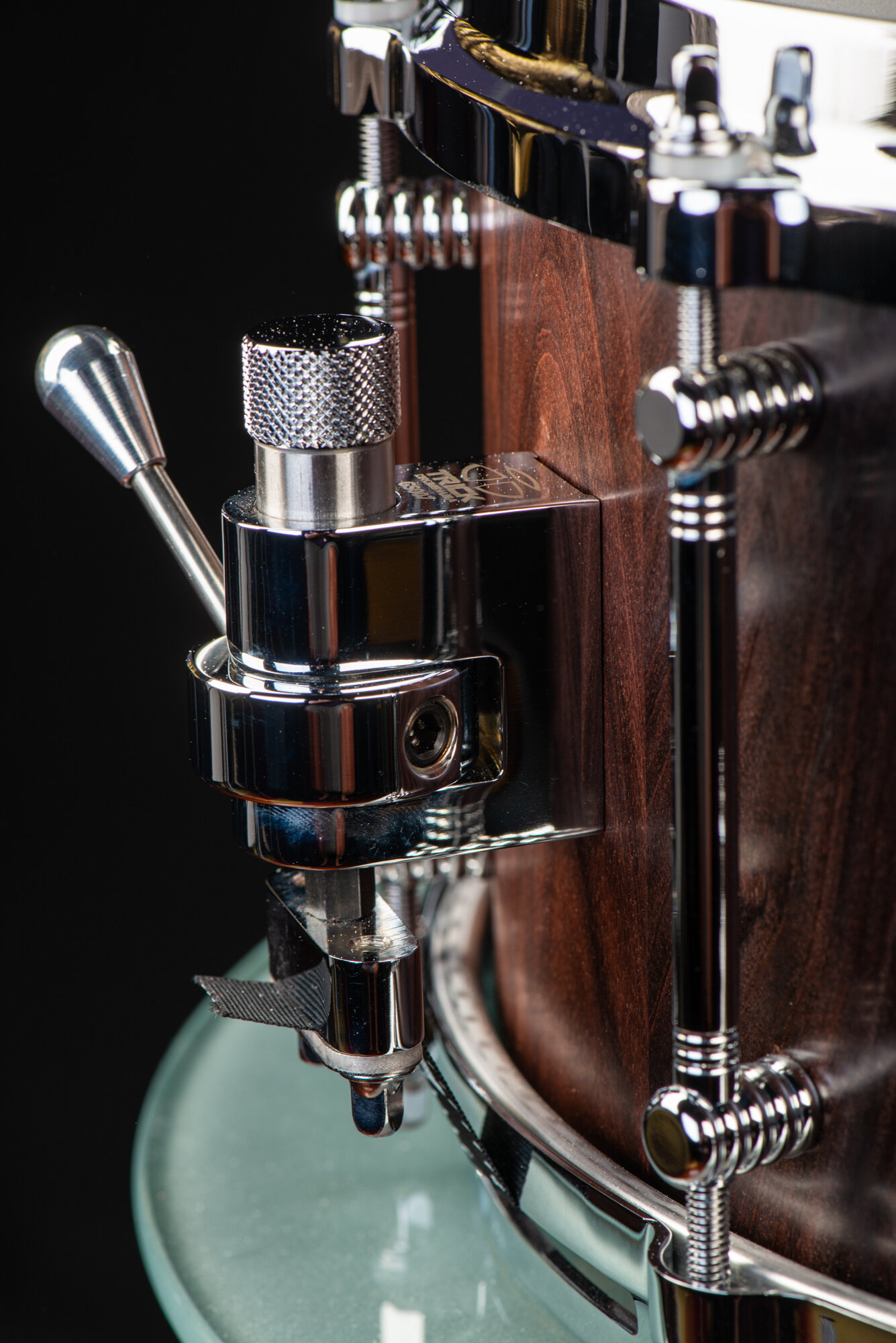 Handmade dark walnut snare drum with a satin finish and polished chrome hardware, featuring a Trick throw-off strainer.