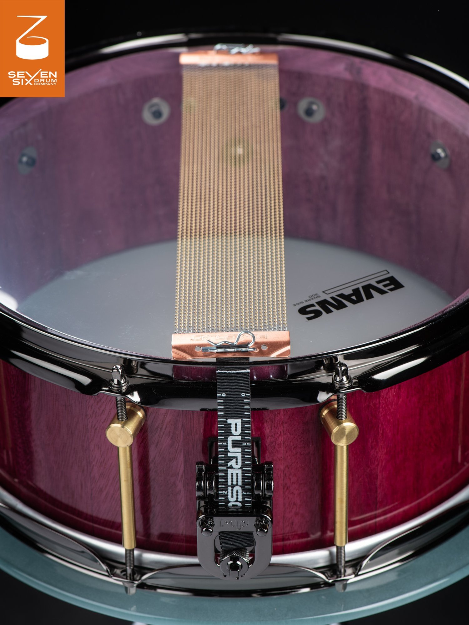 Handmade purpleheart snare drum featuring brass tube lugs, black hoops, and copper-end PureSound snare wires.
