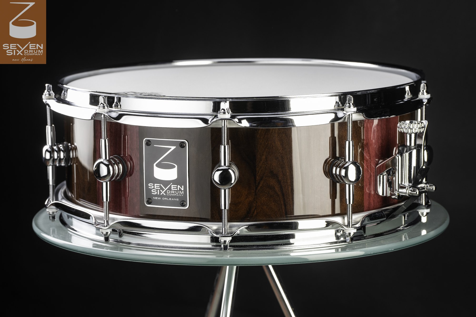 Handmade snare drum with a glossy purpleheart and walnut shell, chrome lugs, and polished chrome hoops.
