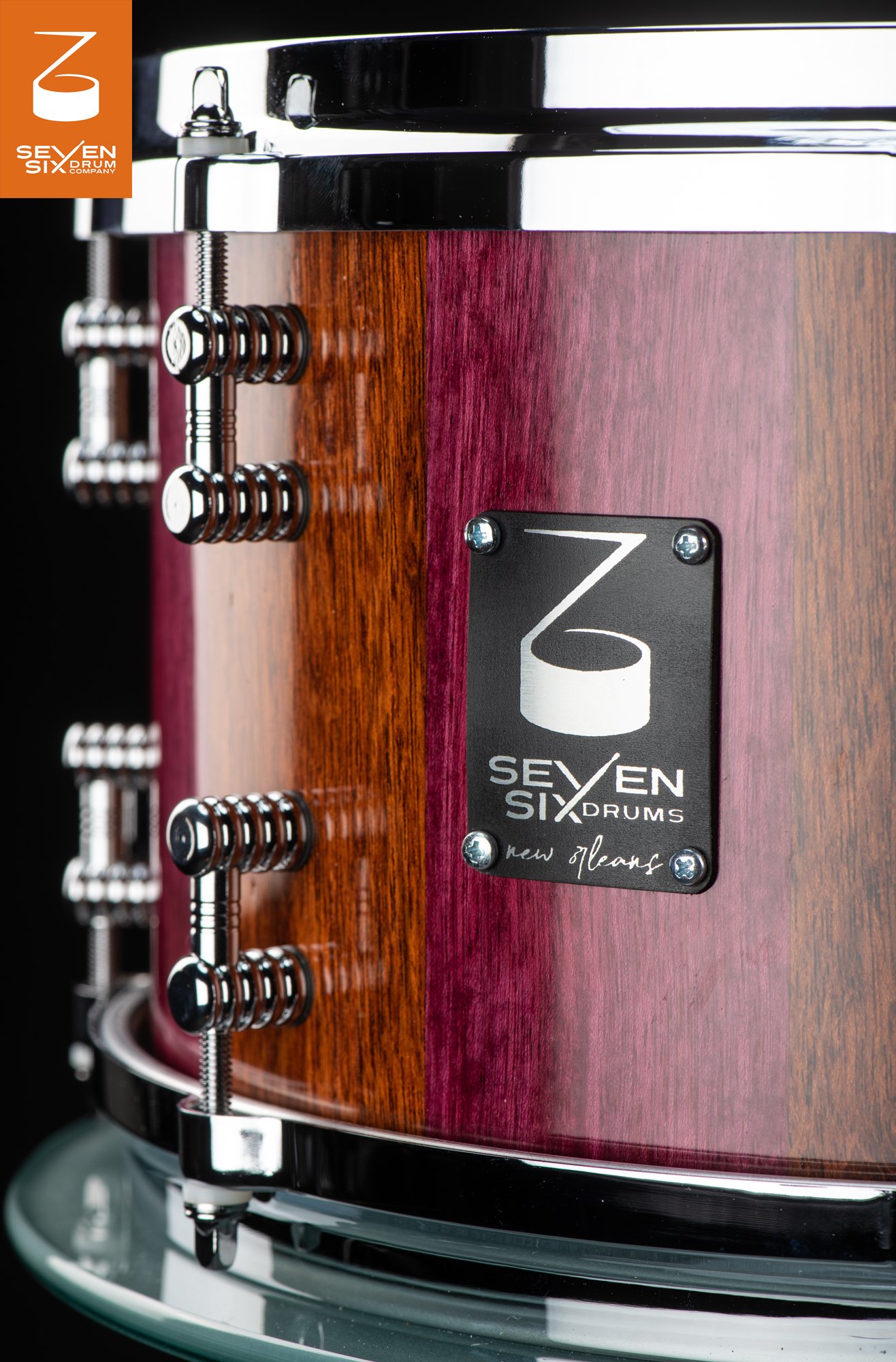 Handmade snare drum with glossy striped purpleheart wood, chrome hardware, and a black Seven Six Drums maker badge.