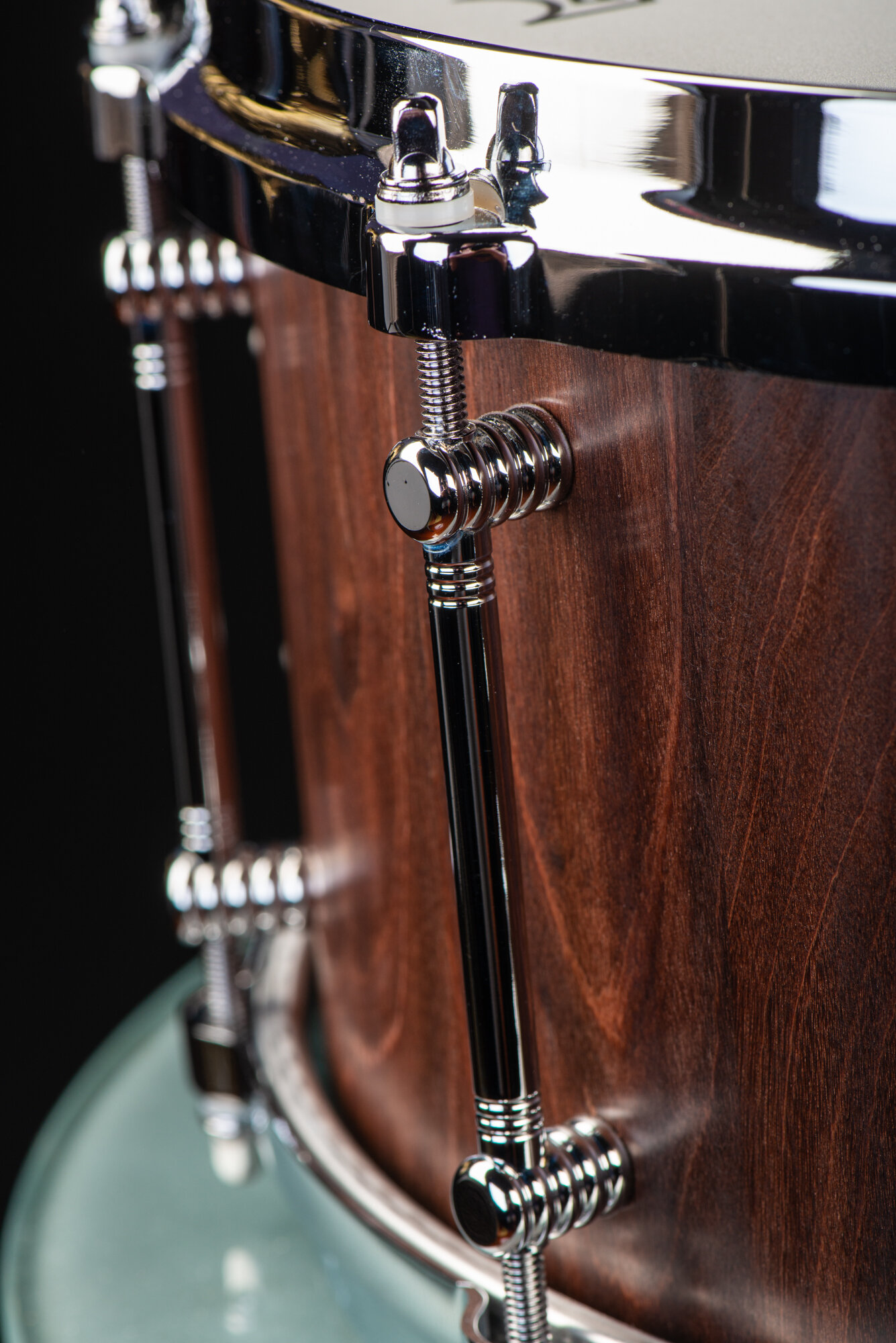 Handmade snare drum featuring a dark walnut shell, satin finish, and polished chrome tube lugs.