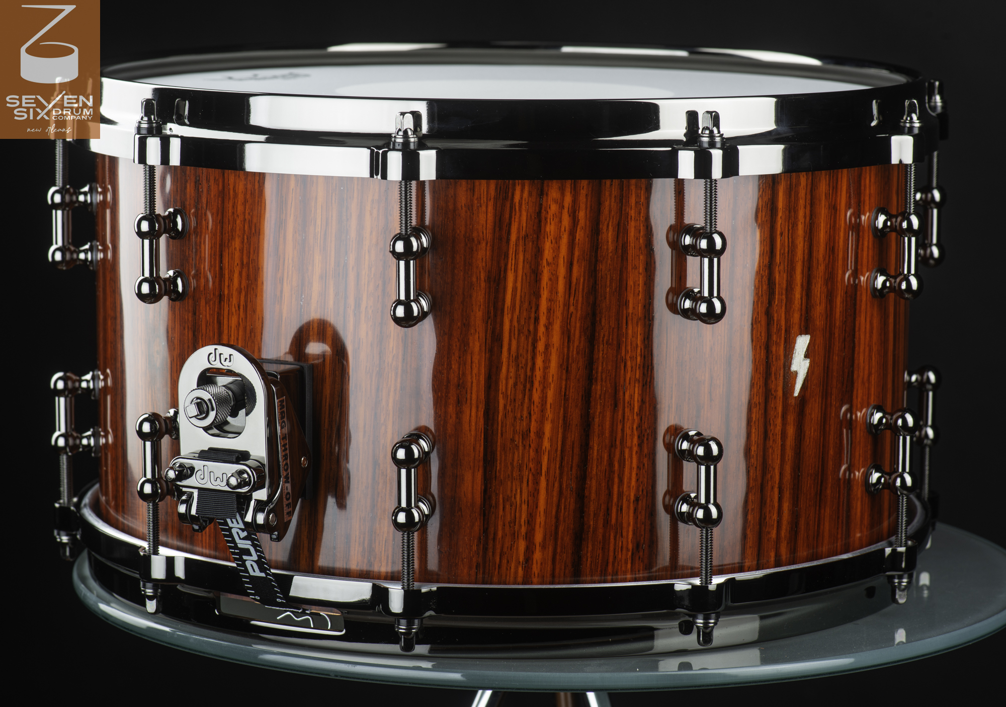 Handmade snare drum with a glossy red vertical-grain wood finish, chrome tube lugs, and a DW MAG throw-off.
