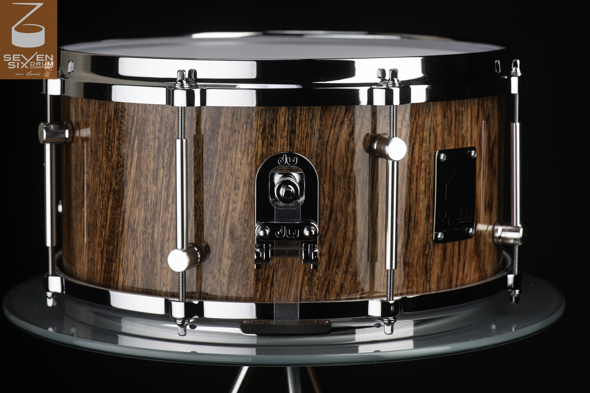 Handmade snare drum featuring a high-gloss wood grain shell with chrome hoops, tube lugs, and a DW butt plate.