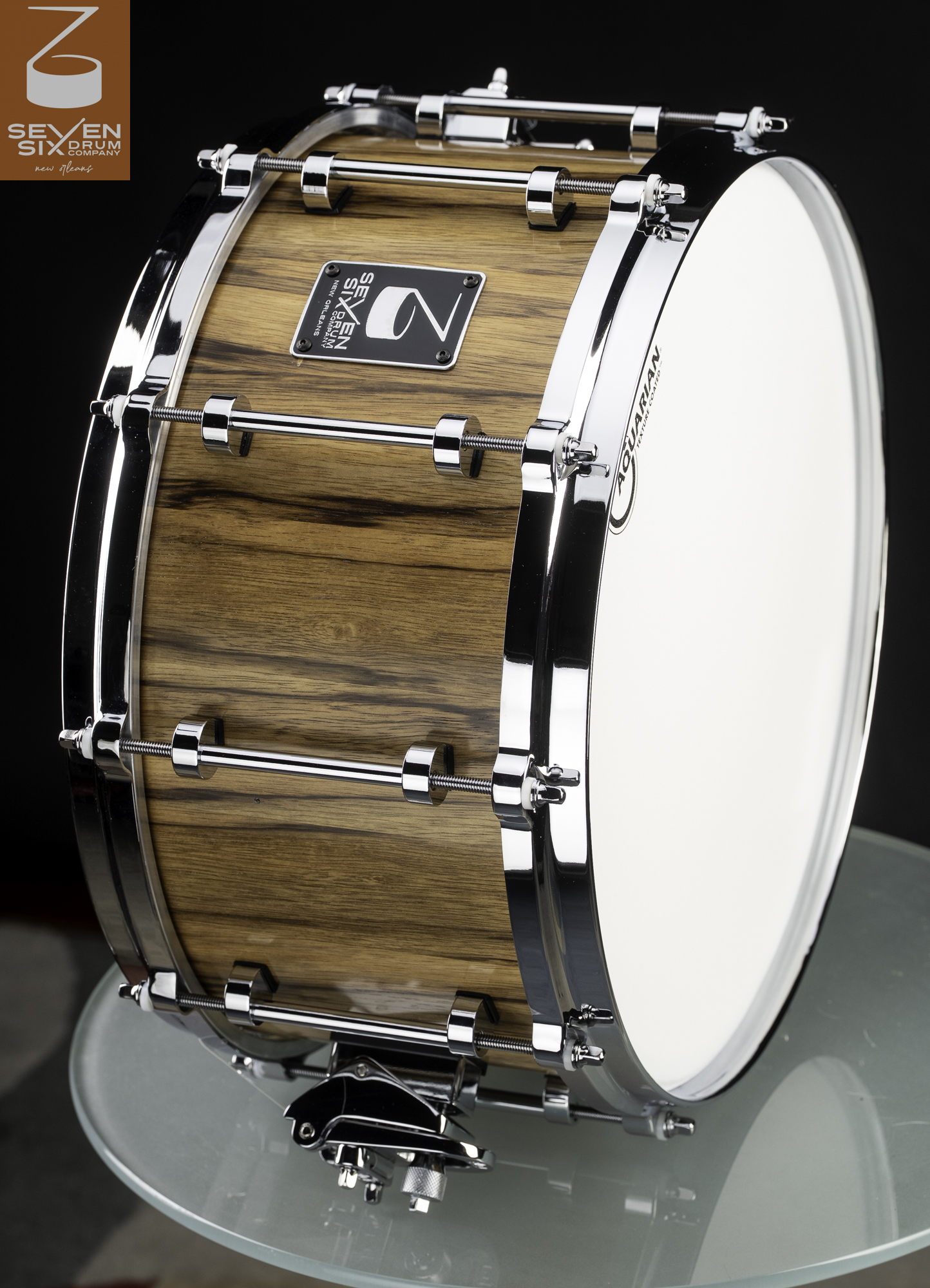 Handmade snare drum featuring a glossy natural wood shell with polished chrome hardware and tube lugs.