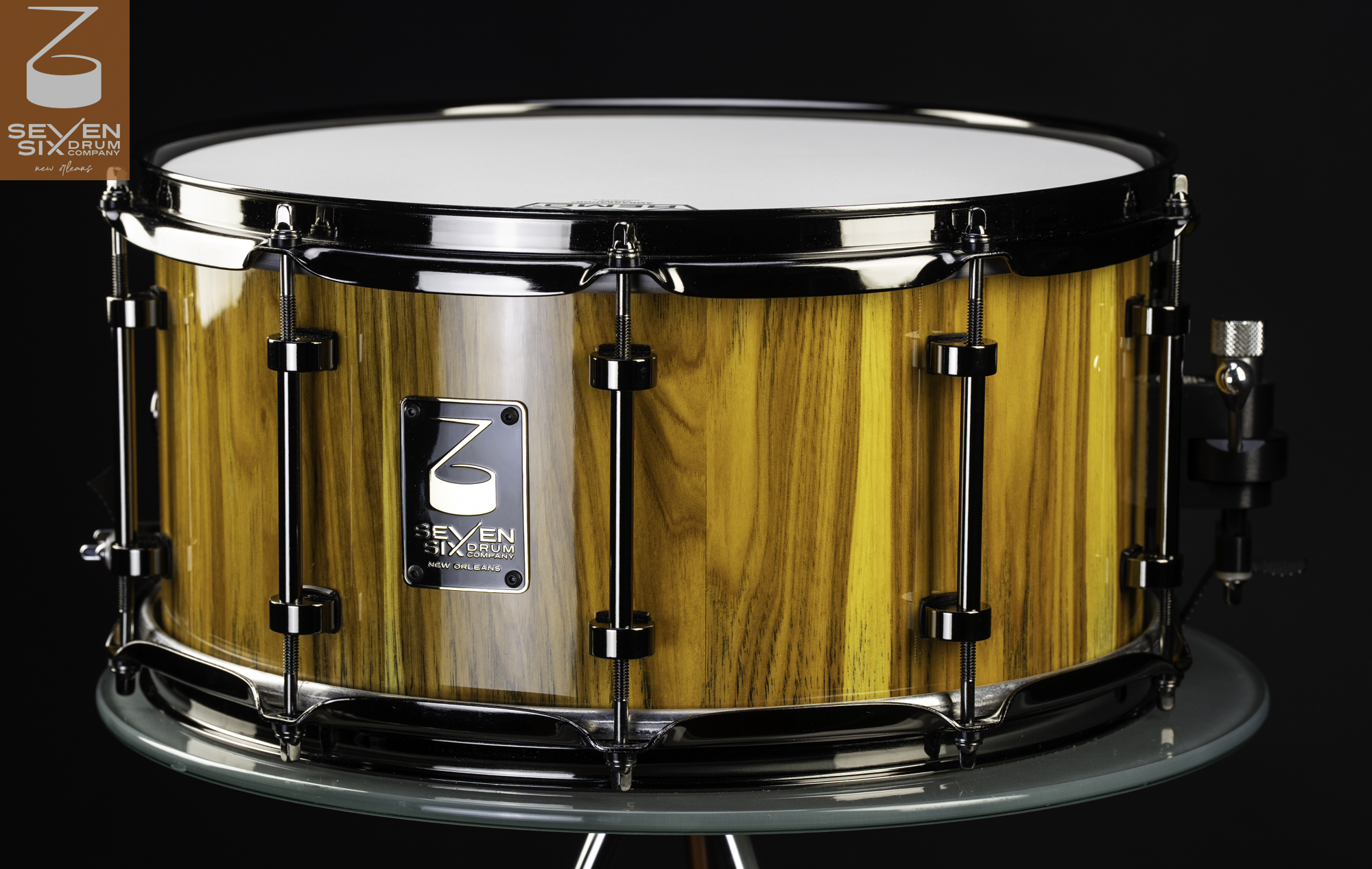 Handmade wood snare drum with a high-gloss yellow grain finish, black nickel tube lugs, and matching hoops.