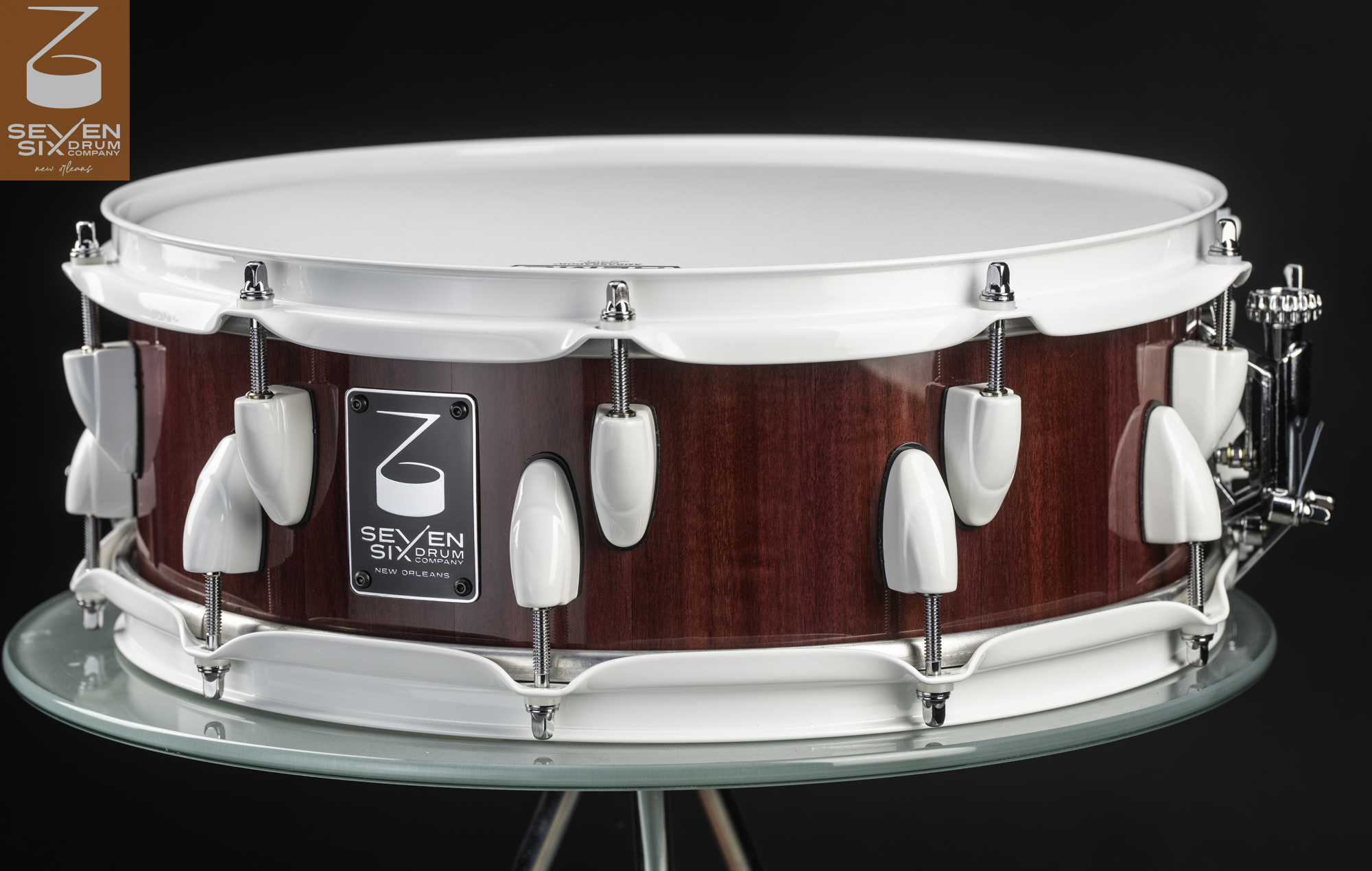 Handmade snare drum featuring a deep red wood shell, white powder-coated hoops, and offset white lugs.