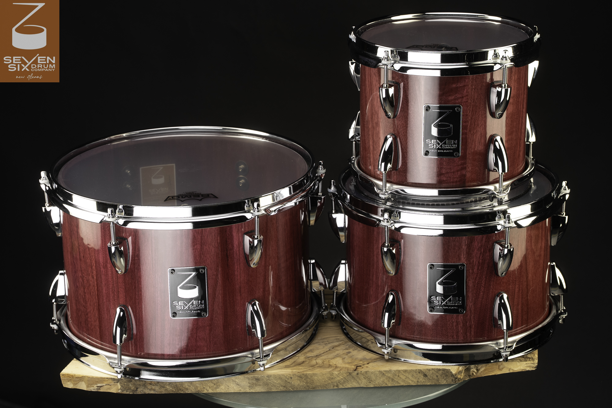 Three drum shells in a gloss purple wood finish with polished chrome hoops and lugs.