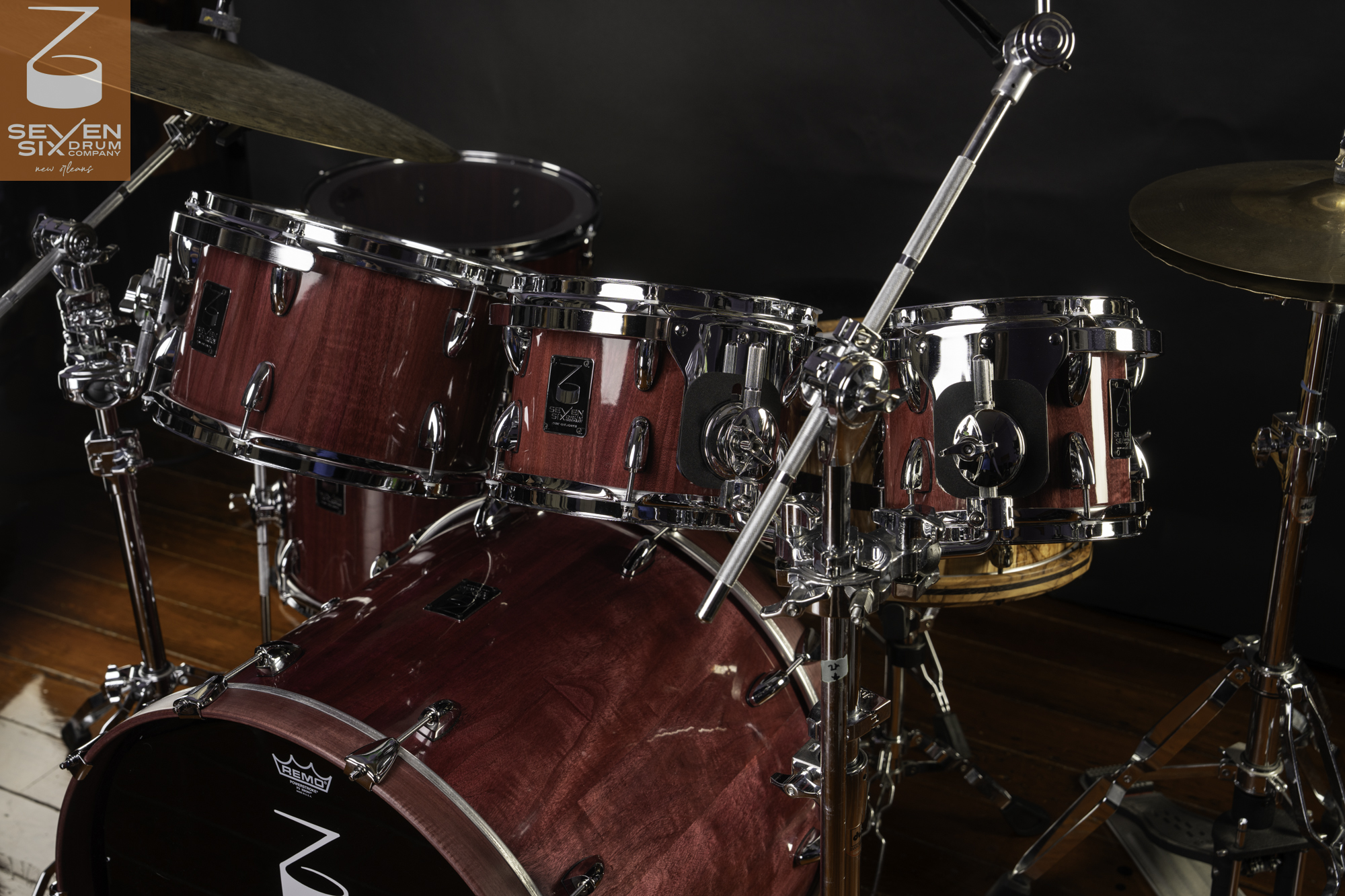 Handmade drum kit featuring glossy Prupleheart wood shells and polished chrome hardware.