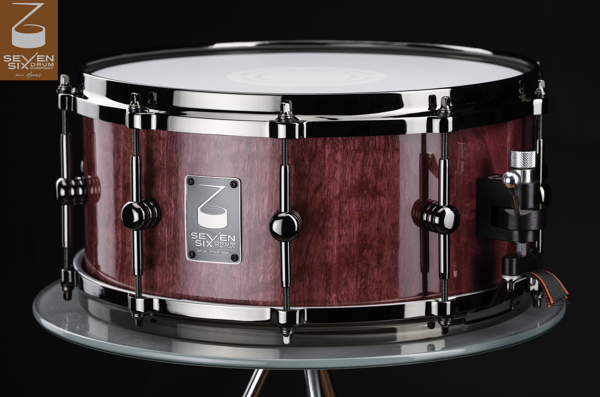 Handmade Purpleheart  snare drum with a glossy purple wood shell, polished black nickel hardware, tube lugs, and a snare throw-off.