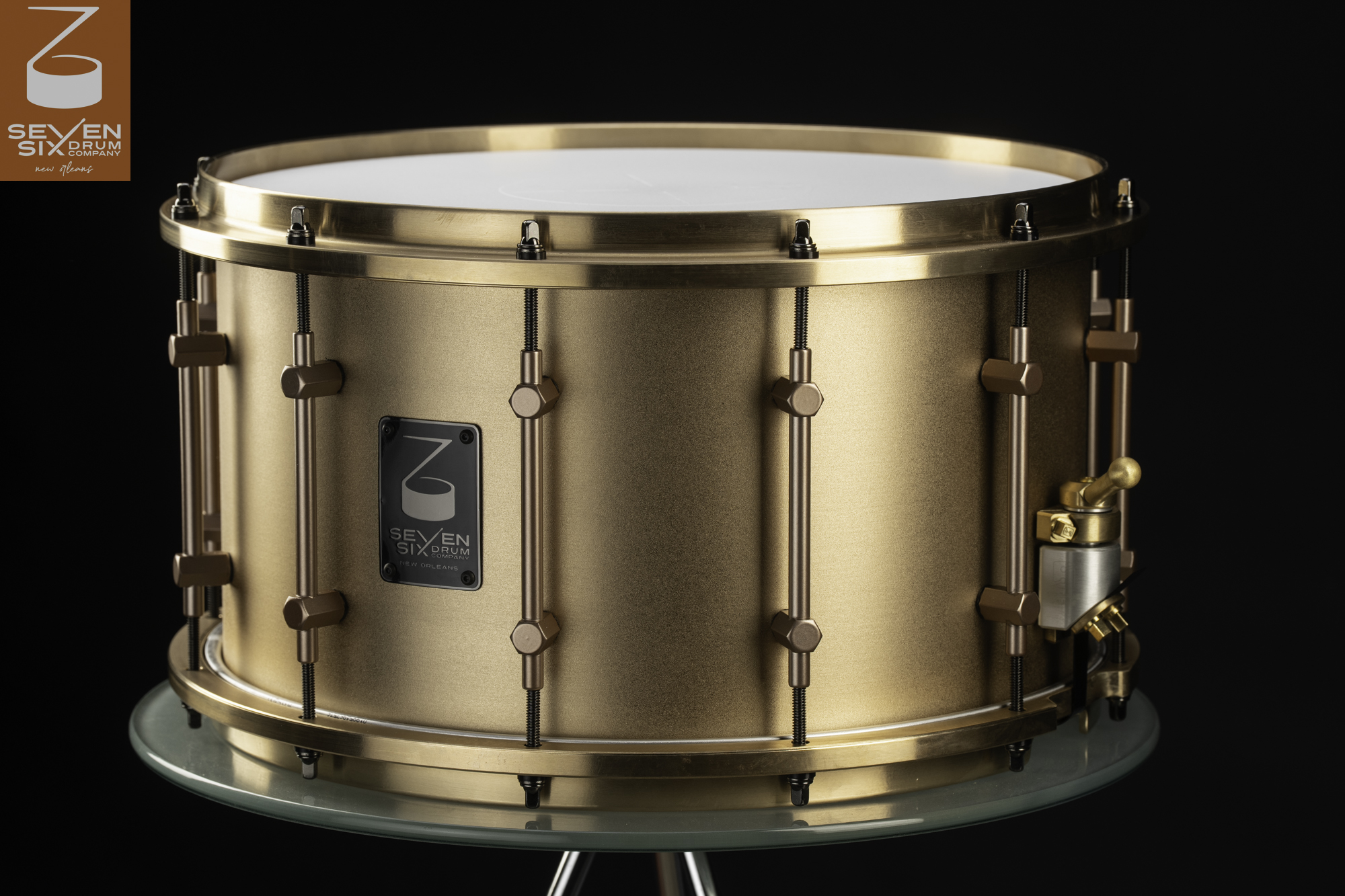 Satin cast bronze snare drum with matching cast hoops, full-length tube lugs, and a brass throw-off.