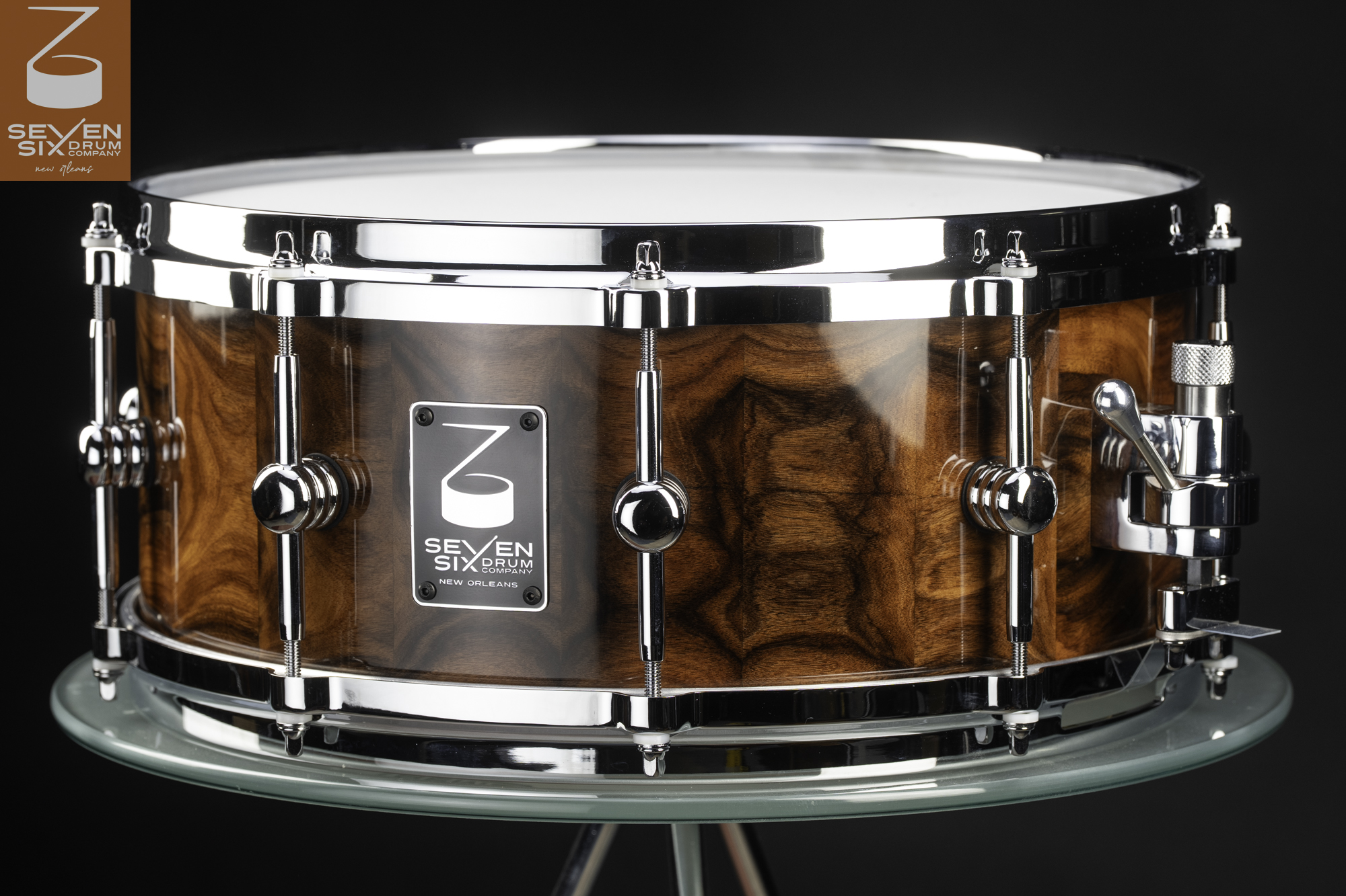 Handmade snare drum with a high-gloss figured Bolivian Rosewood shell, polished chrome hoops, rounded lugs, and side throw-off.