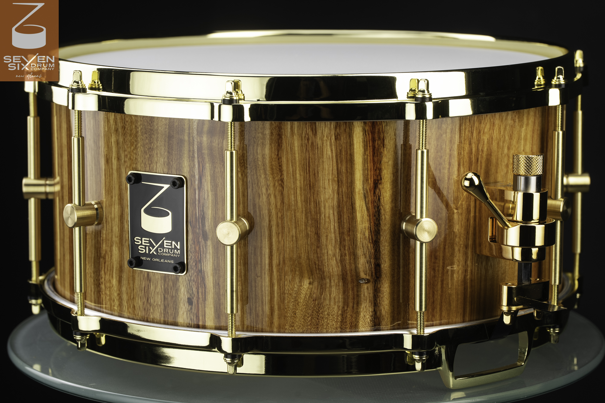 Handmade canarywood snare drum with a glossy natural wood shell, polished gold diecast hoops, brass tube lugs, and a gold strainer.